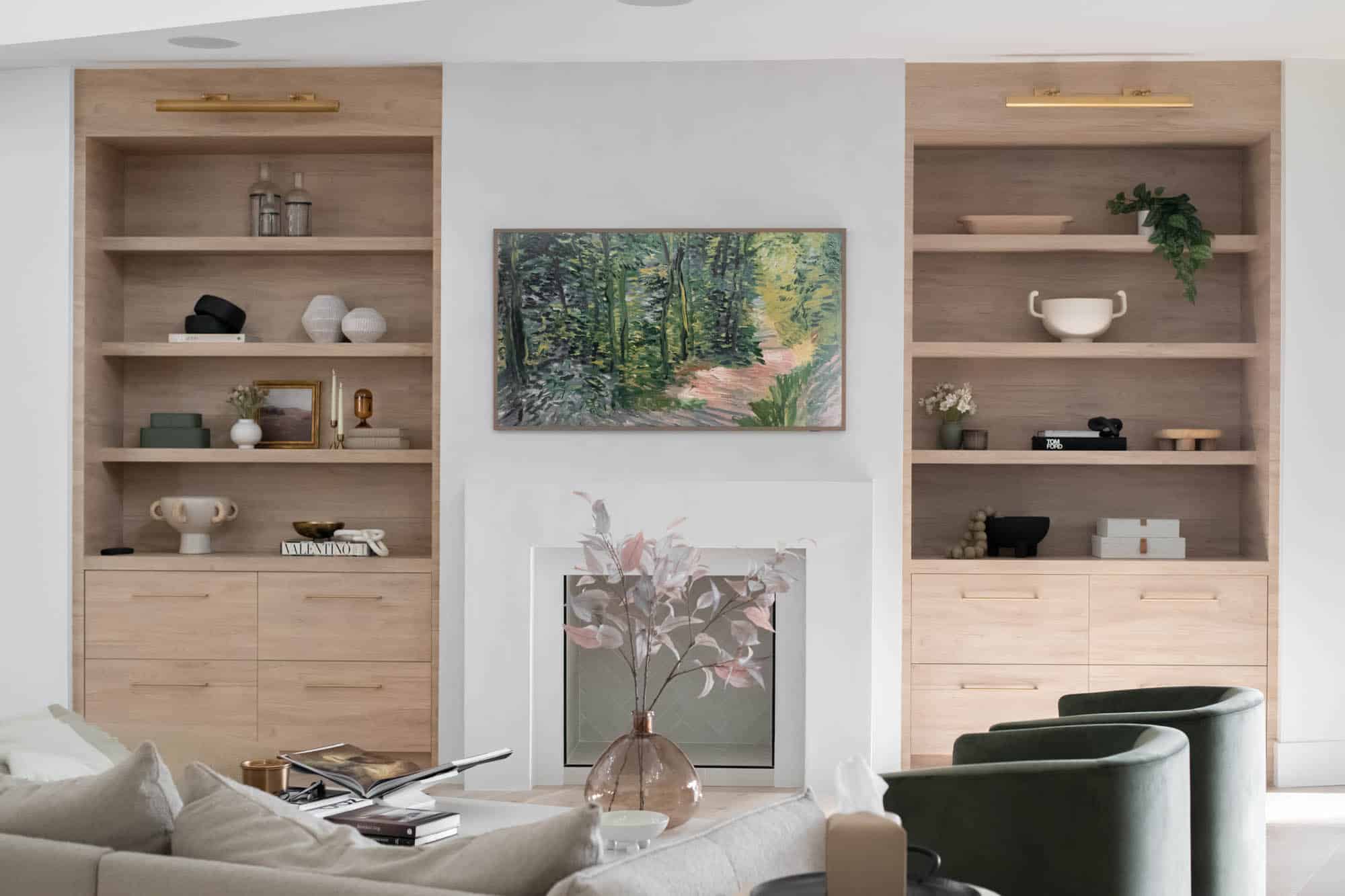 Modern living room with custom built-in shelving, natural wood cabinetry, and elegant interior design from a luxury home remodel in Centennial Hills Las Vegas by Kingdom & Co.
