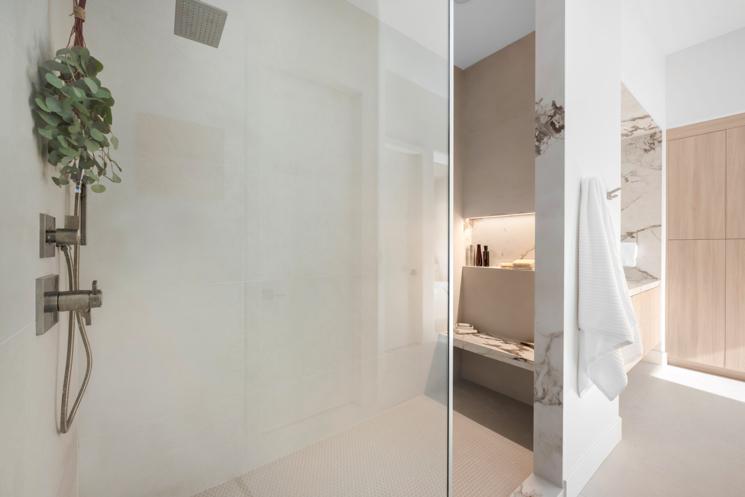 Walk-in doorless shower with large-format porcelain walls in Las Vegas home by Kingdom & Co.