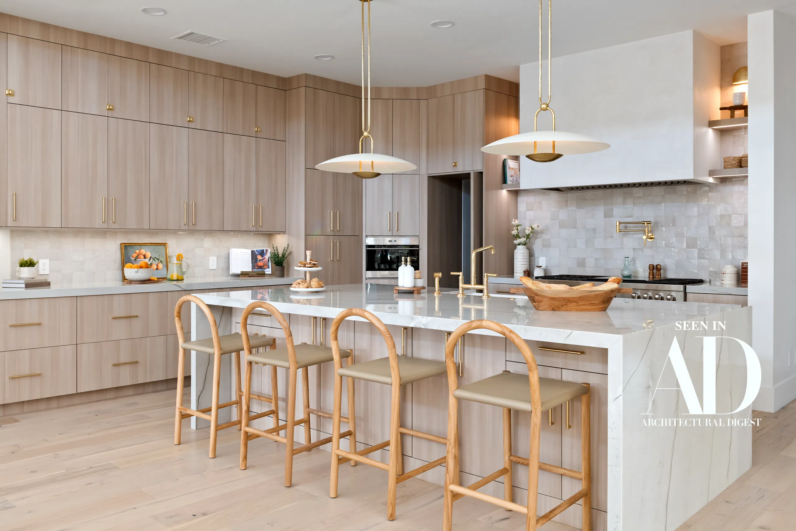 The Carmella custom kitchen remodel in South Summerlin by Kingdom & Co. featuring marble island and brass hardware