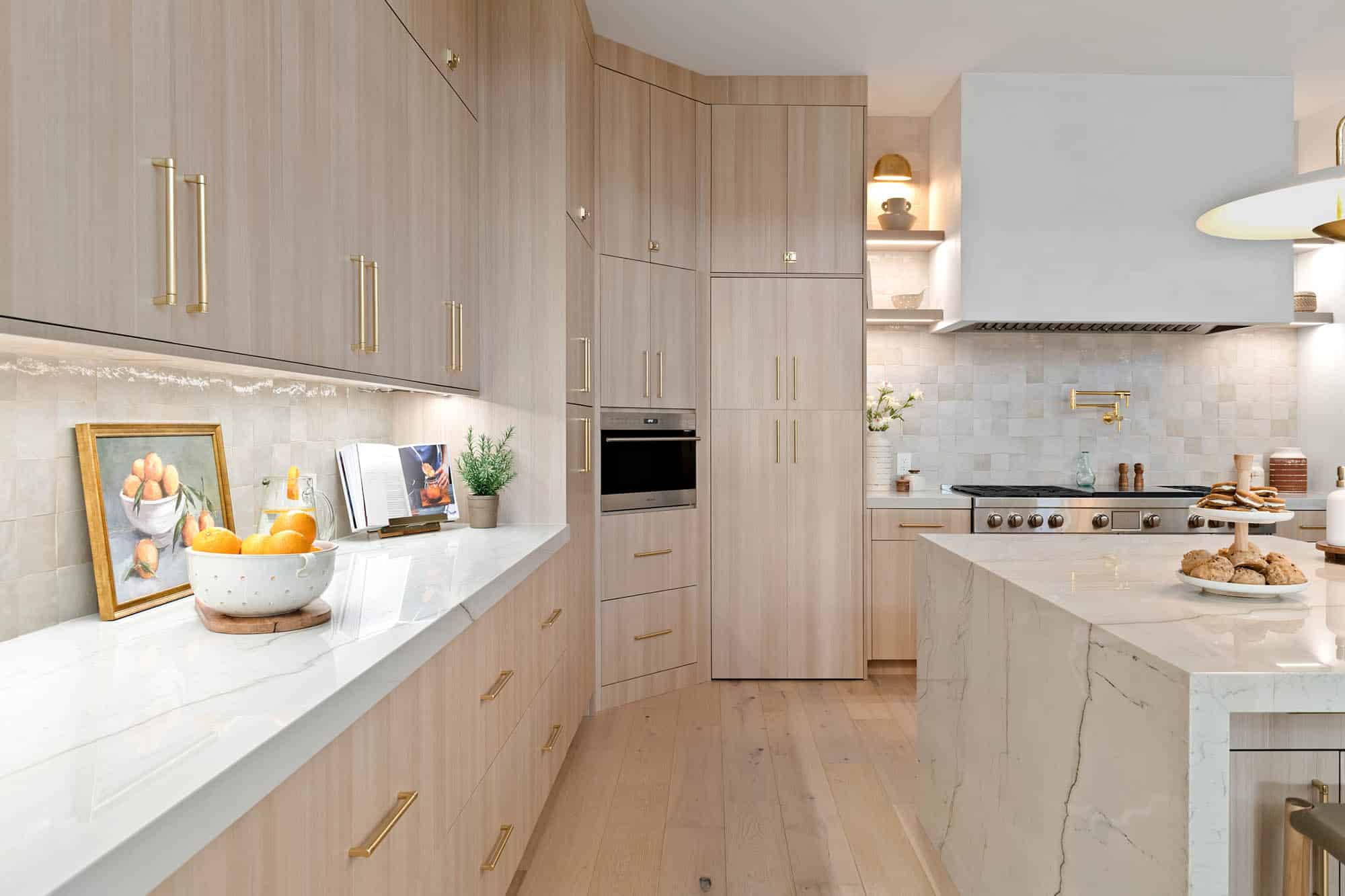 A luxurious kitchen remodel by Kingdom & Co in Centennial Hills, Las Vegas, featuring custom light wood cabinets, marble countertops, and modern decor.