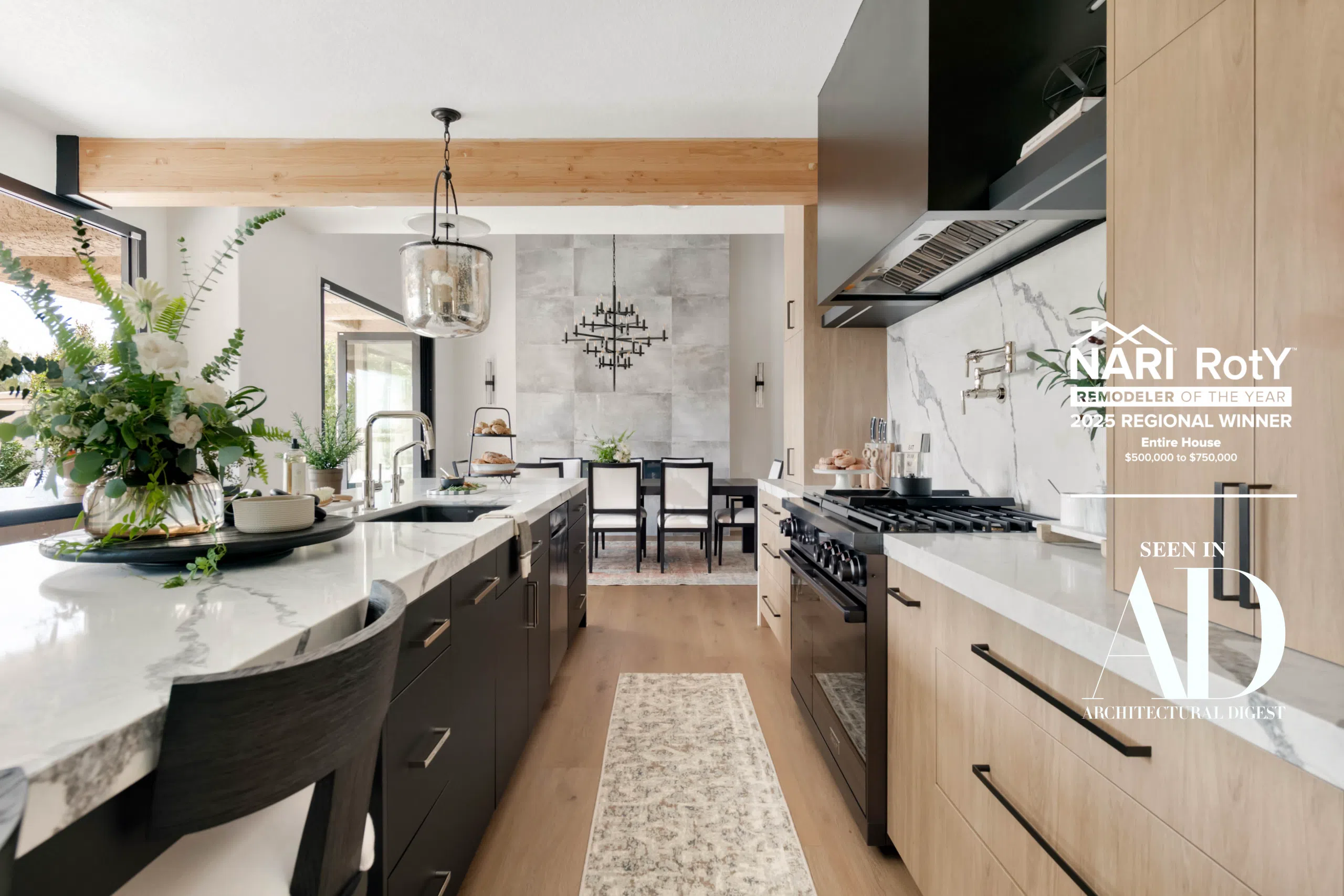 The Parker NARI 2025 Remodeler of the Year winning kitchen with marble waterfall island, light wood cabinetry, gas range, and Architectural Digest feature