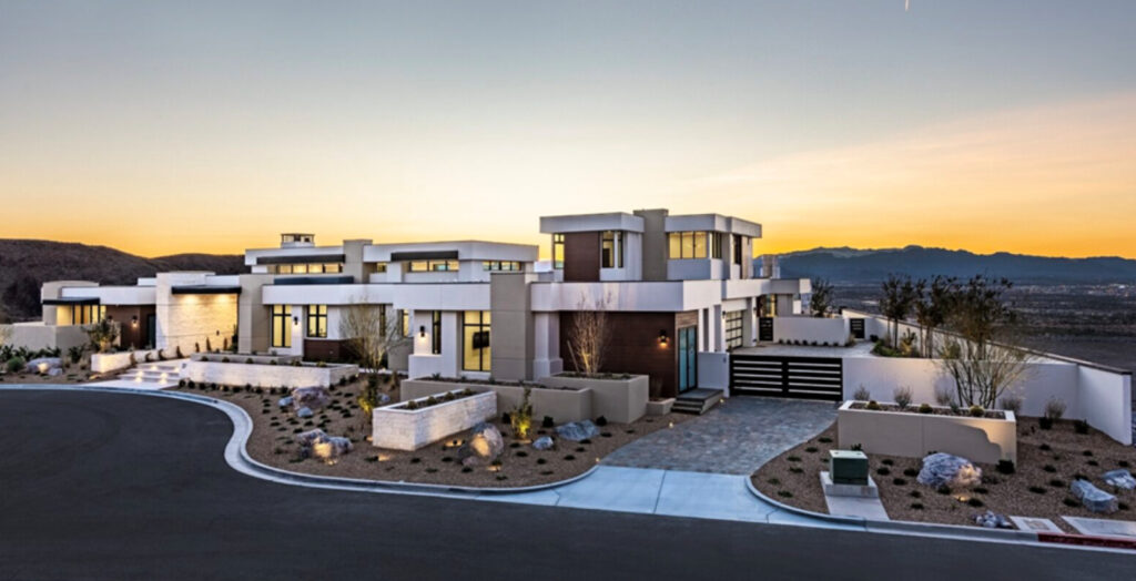 Modern luxury home exterior by Kingdom & Co with bold lines, large glass windows, and desert landscaping