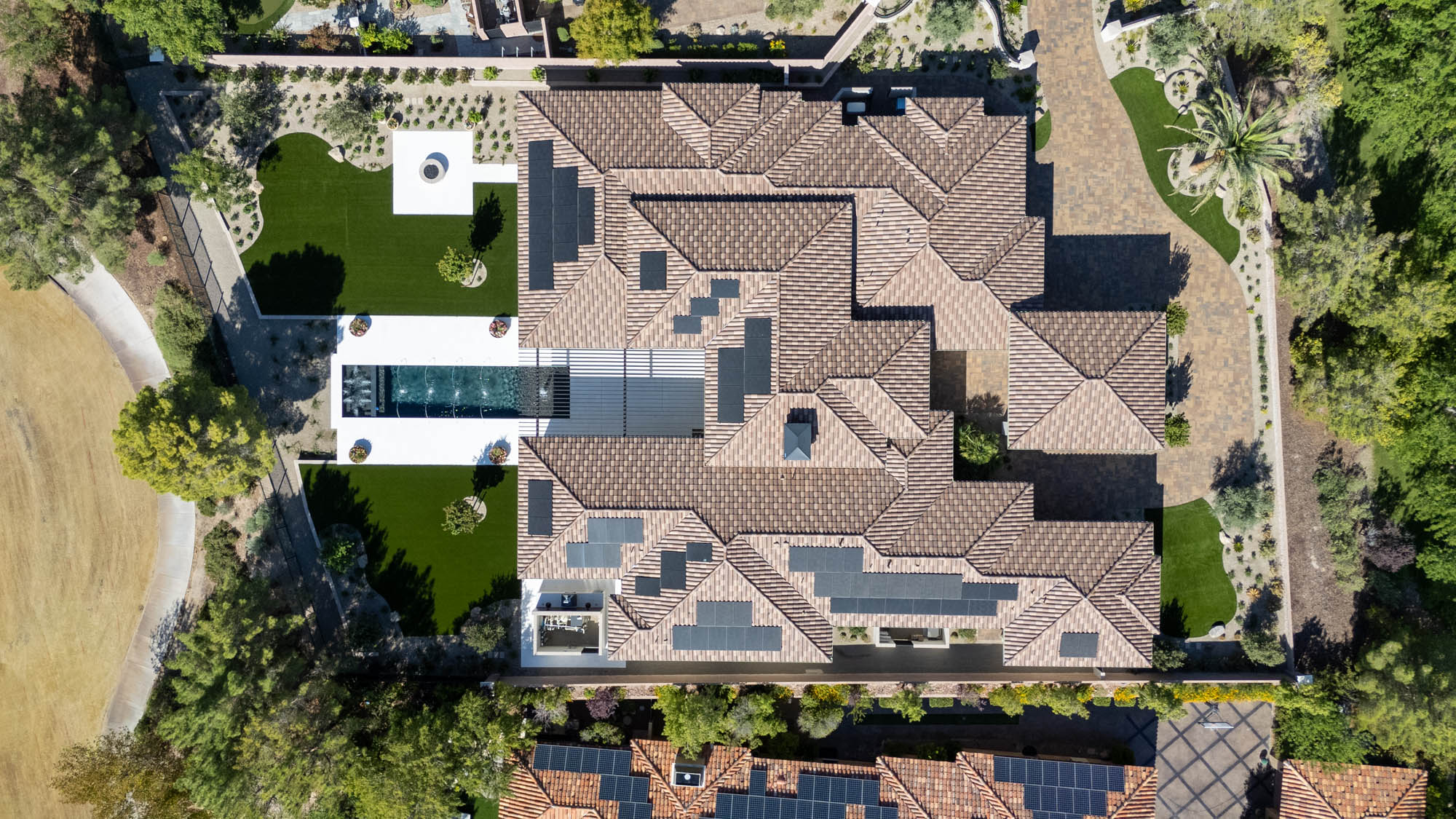 custom-new-build-southern-highlands_kingdomandco Aerial view of luxury Las Vegas estate with solar panels, custom pool, and landscaped backyard built by Kingdom & Co.