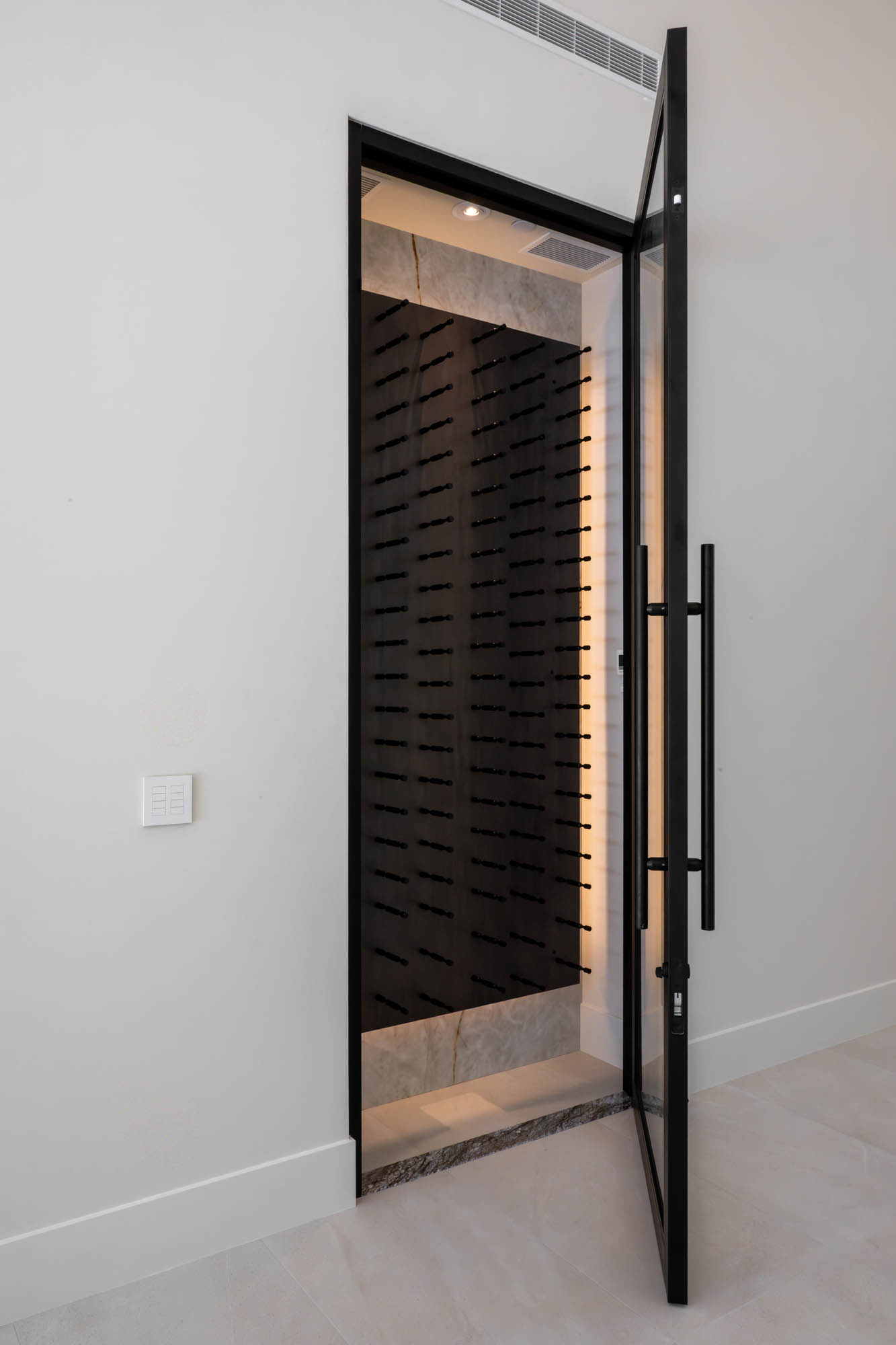 custom-new-build-southern-highlands_kingdomandco Glass door entry to modern wine storage room in a custom Kingdom & Co home in Southern Highlands.