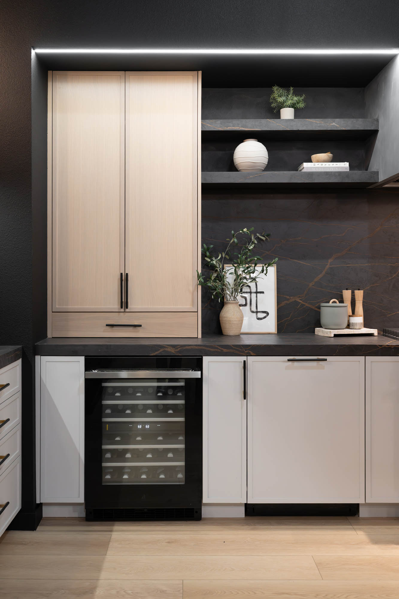 FergusonShowroom_CommercialRemodel_Kingdomandco Modern kitchen cabinetry with integrated wine cooler and black stone backsplash designed by Kingdom & Co Las Vegas.