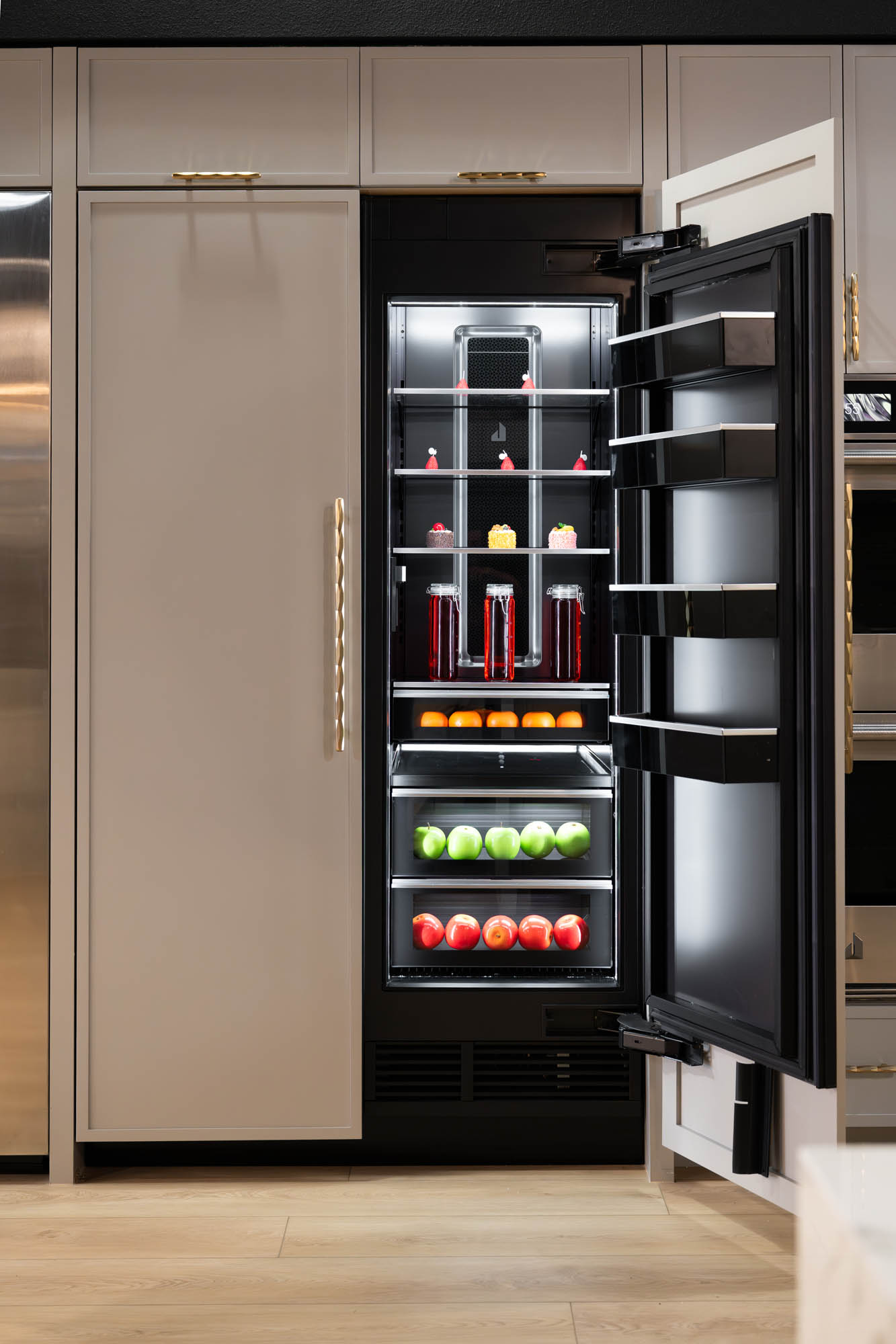 Built-in luxury refrigerator with illuminated interior and matte cabinetry designed by Kingdom & Co Las Vegas.