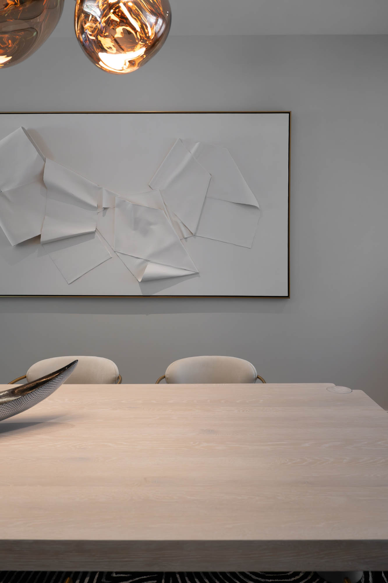 The Lucida_summerlin-south_luxury-remodel_kingdomandco Minimalist dining table with sculptural art and pendant lighting in Summerlin South remodel by Kingdom & Co.