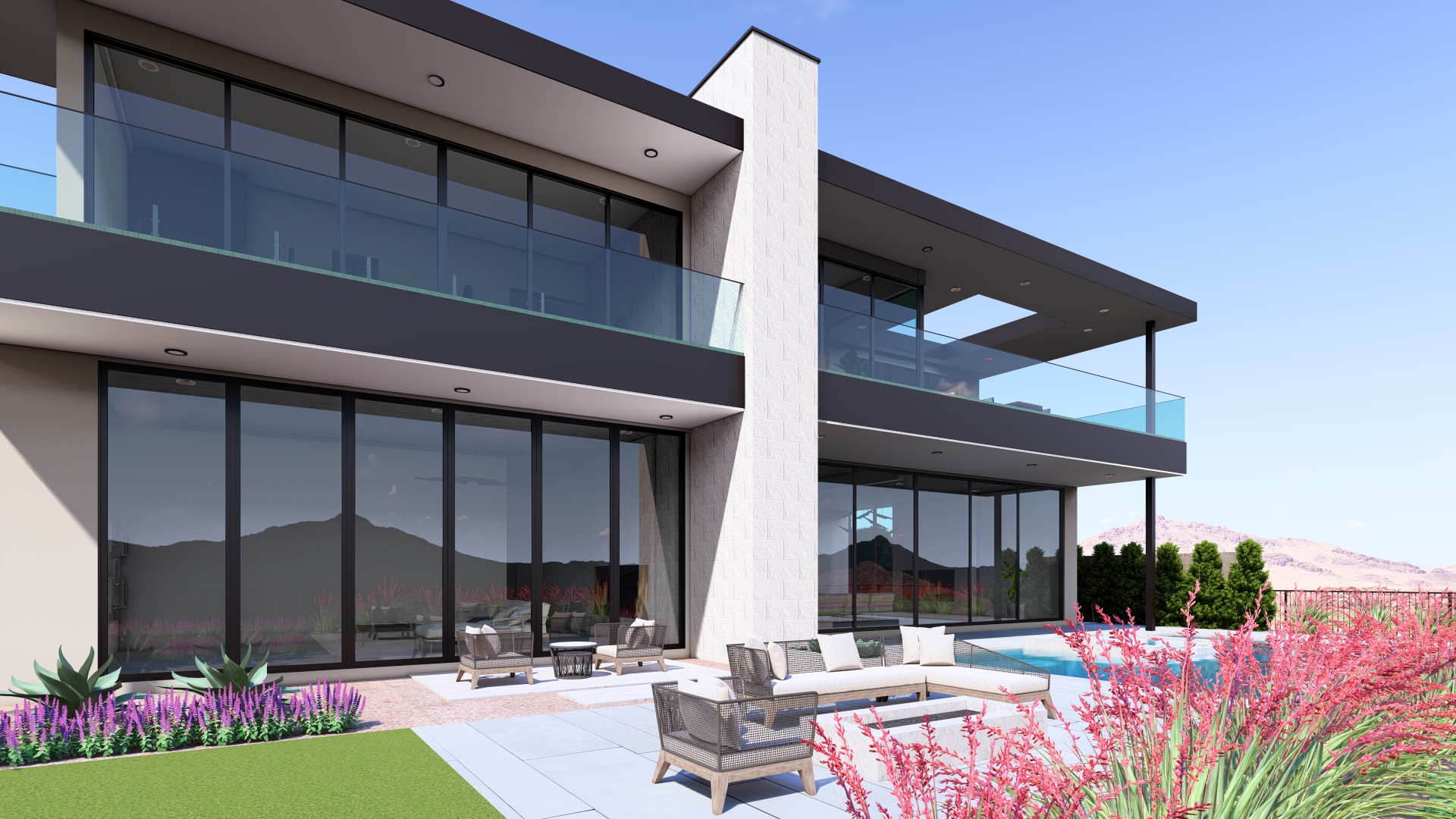 Rear exterior of Kingdom & Co.’s Ascaya luxury home, showcasing expansive glass walls, modern balconies, outdoor seating, and vibrant desert landscaping.