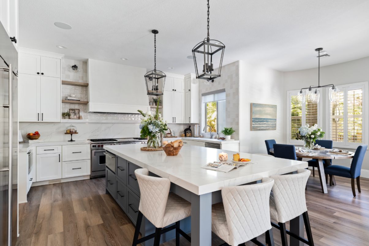 Modern kitchen with white and blue kitchen cabinets, white kitchen island, and tiled accents.