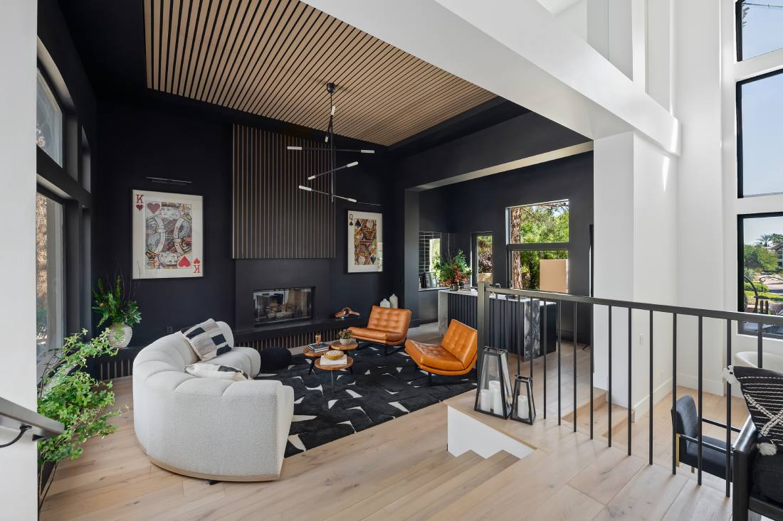 A view looking down into a living space featuring all black walls and modern furniture.