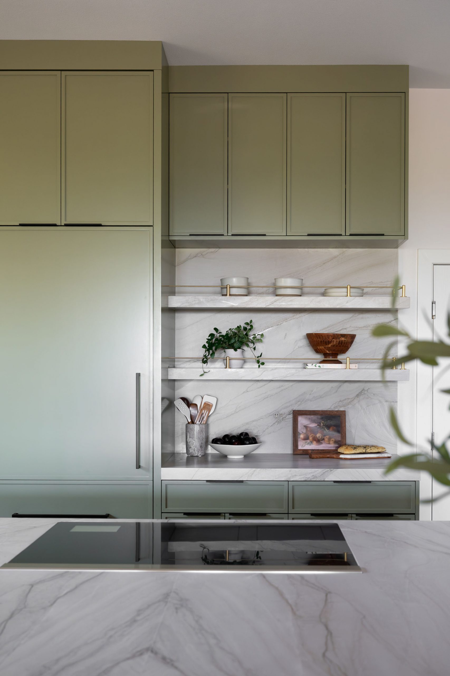 Marble floating shelves and integrated panel refrigerator in sage green Summerlin kitchen, Kingdom & Co.