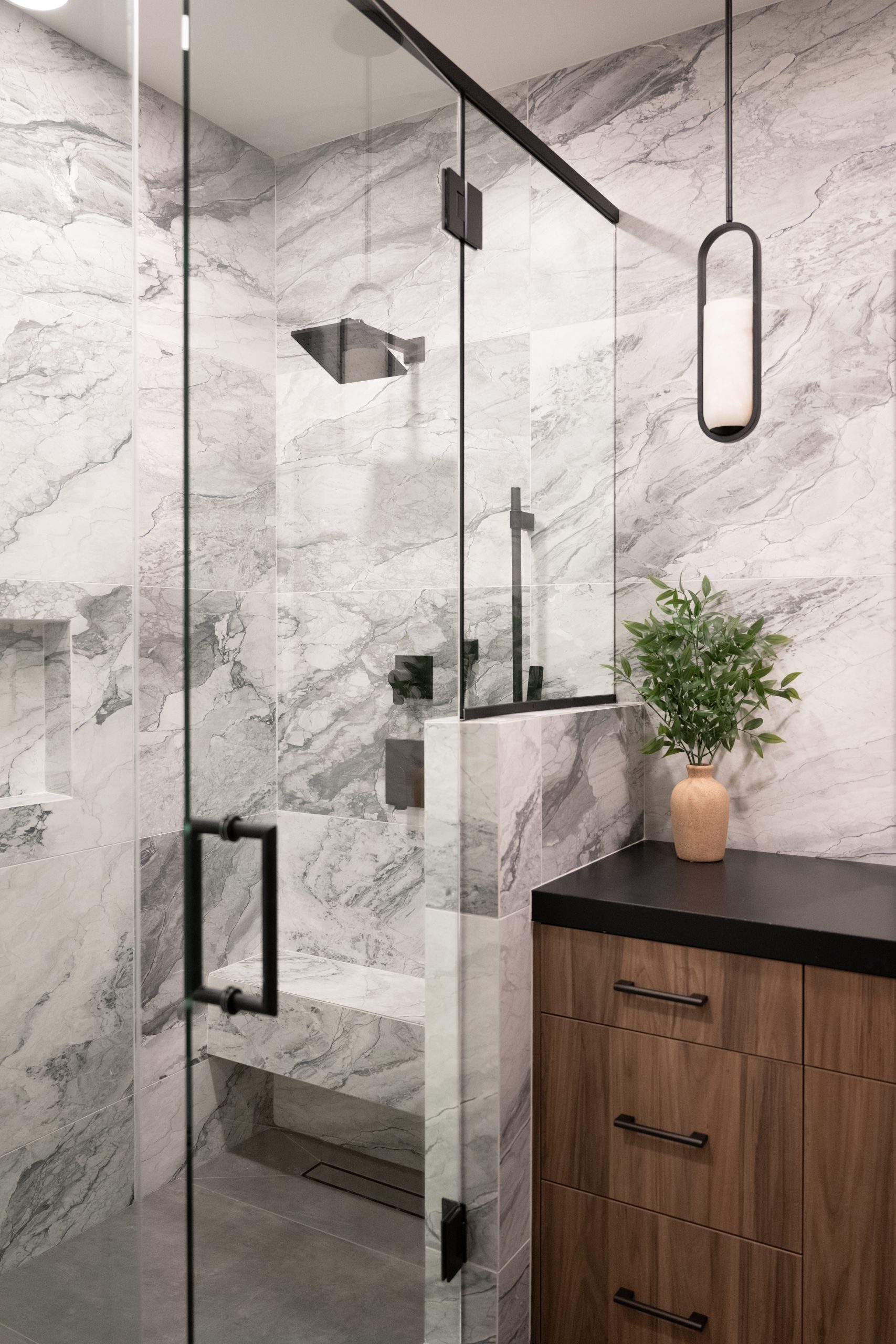 Guest bathroom walk-in shower with book-matched marble walls and marble bench, Kingdom & Co. The Lakes remodel.