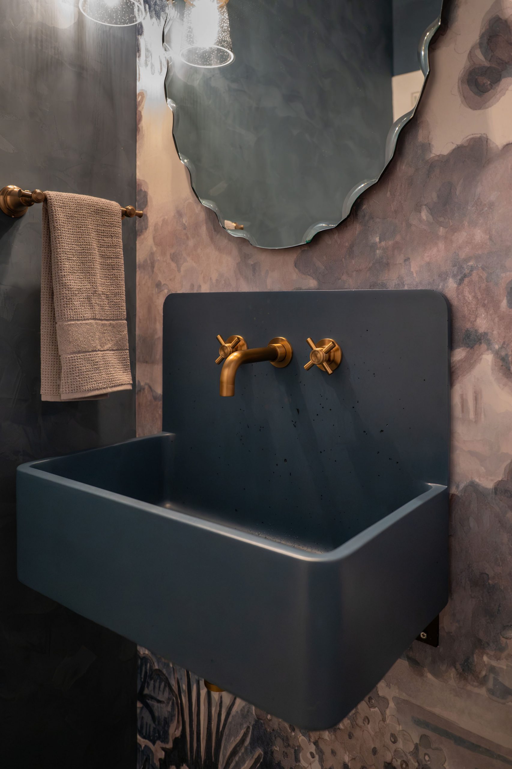 The Astoria_SummerlinRemodel Blue concrete wall-mount sink with brass cross-handle faucet and painterly wallpaper, Kingdom & Co. Summerlin.