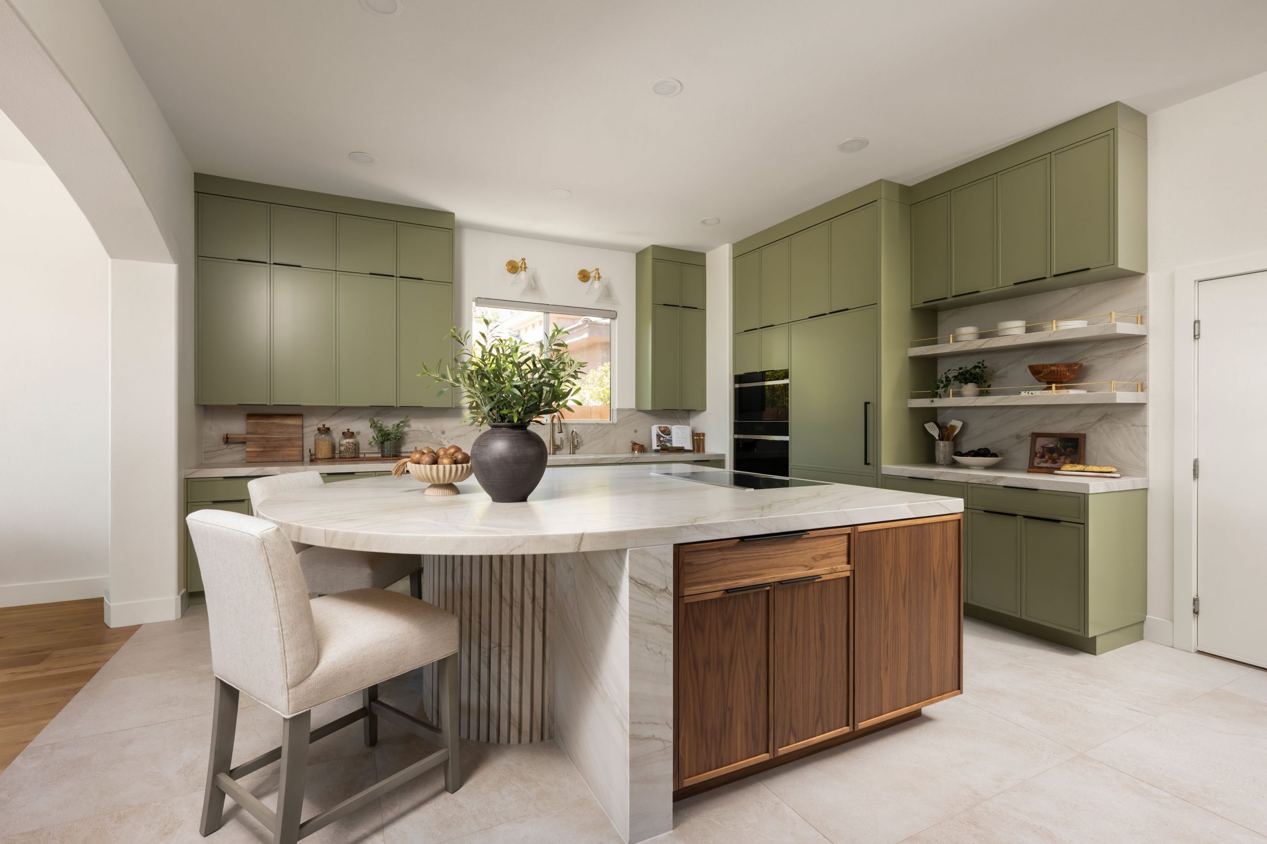 the-astoria_summerlinremodel Sage green cabinets, walnut island back, and marble waterfall counter in Summerlin kitchen by Kingdom & Co.