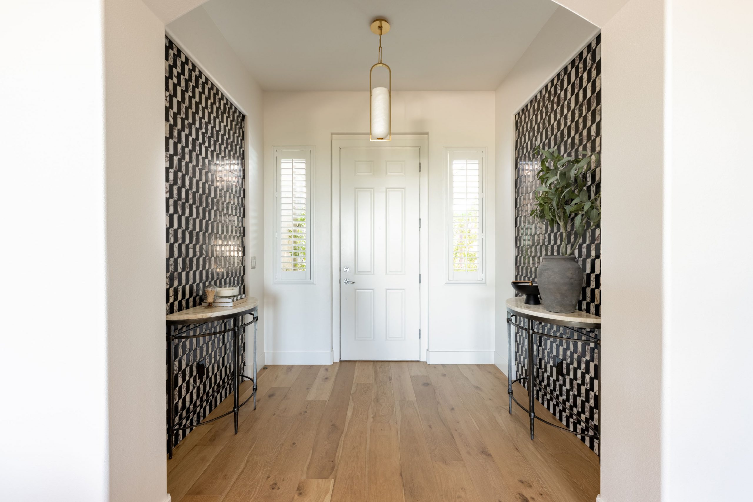 Entryway with dual demilune consoles and Calacatta Viola accent walls, Kingdom & Co. Summerlin remodel.