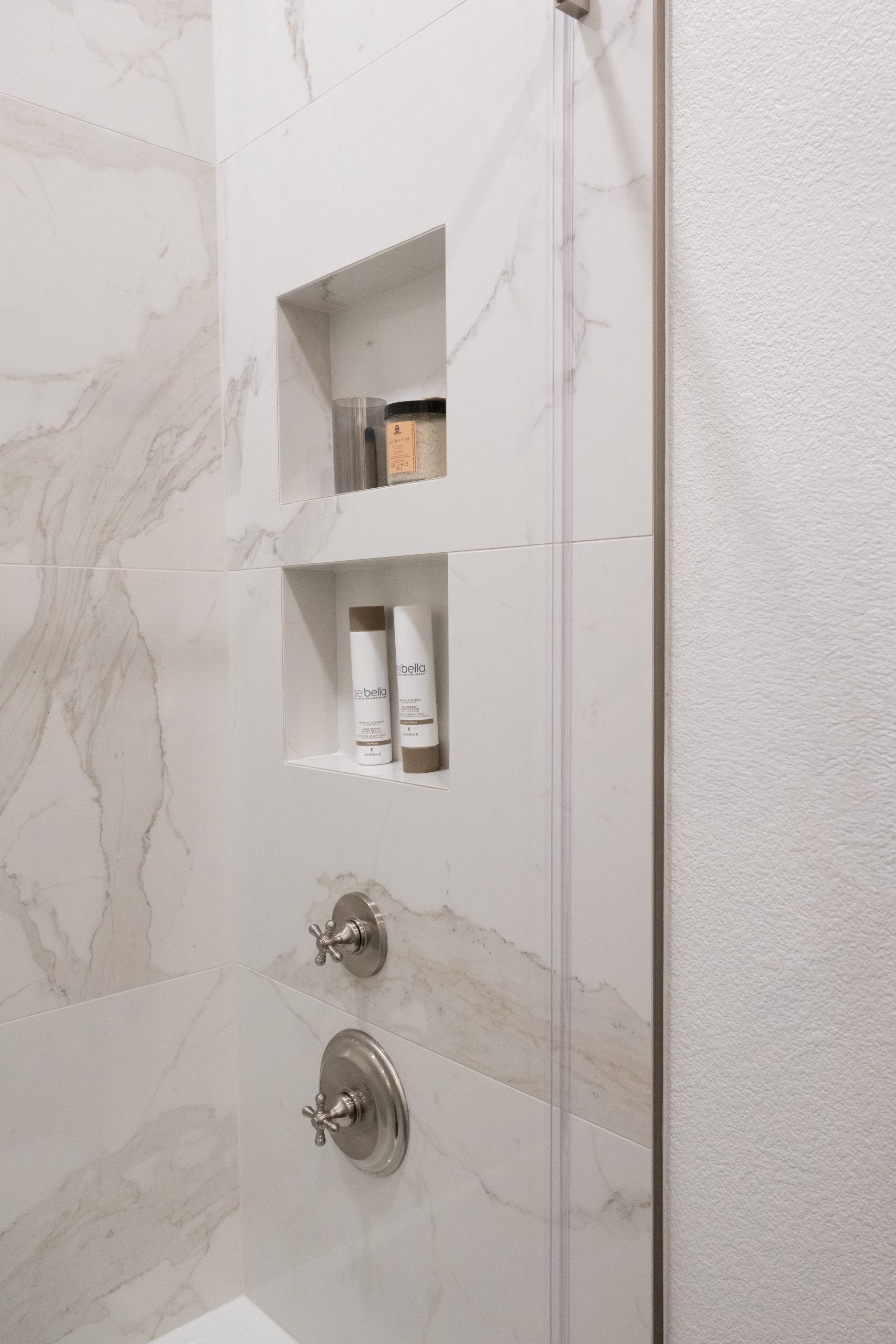 Calacatta marble shower with dual stacked niches and cross-handle valve, Kingdom & Co. The Lakes guest bath.