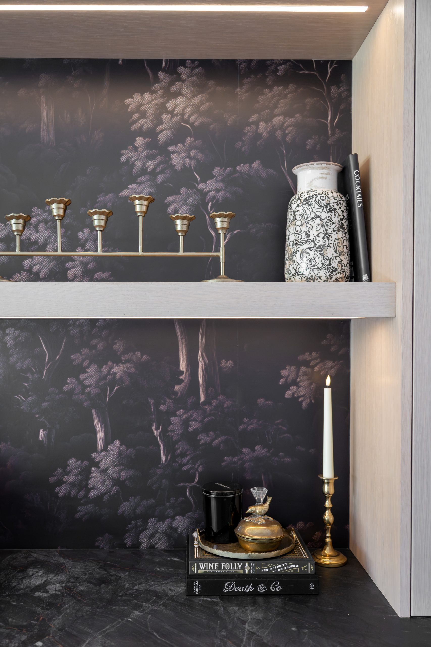 the-hearthstone-the-lakes-kitchen-remodel-kingdom-co Botanical wallpaper vignette with brass candelabra styling above black stone counter, Kingdom & Co. dry bar.