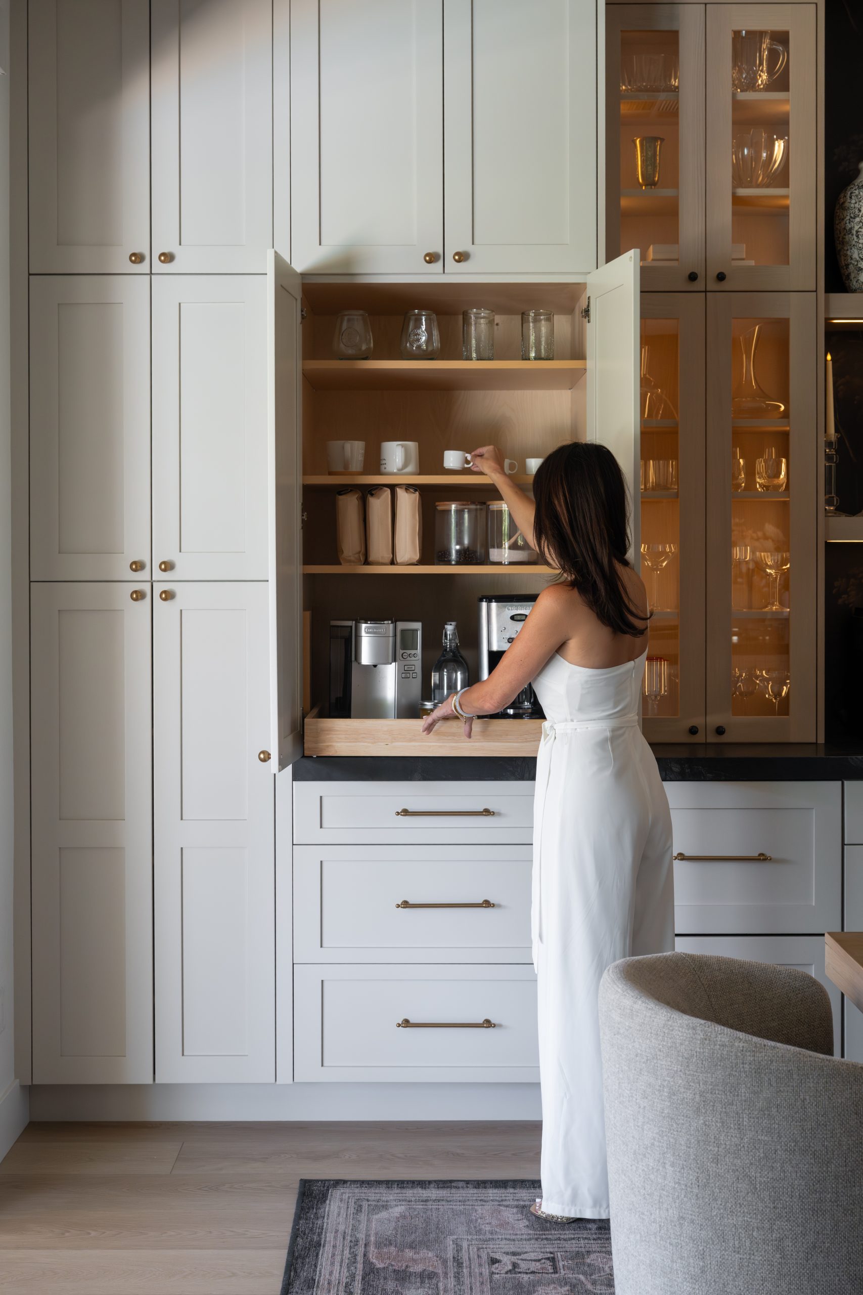Interior designer, Erin Othick opening the appliance garage coffee cabinet in The Lakes kitchen by Kingdom & Co.