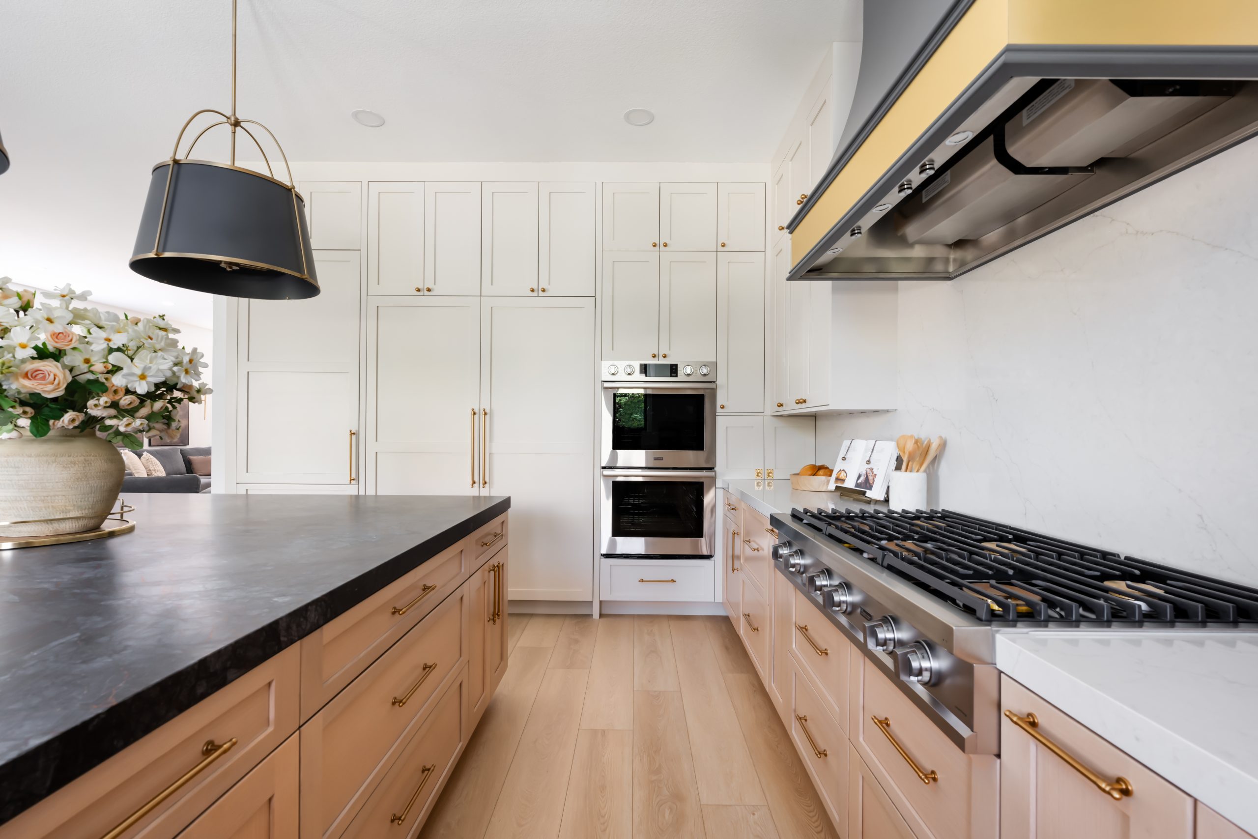 Wolf double wall ovens and cooktop under custom charcoal hood, The Lakes kitchen remodel by Kingdom & Co.