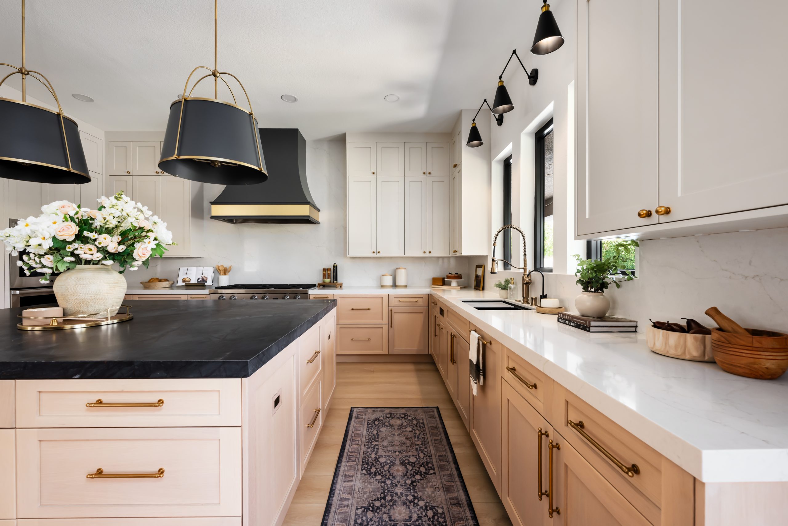 the-hearthstone-the-lakes-kitchen-remodel-kingdom-co Wide view of The Hearthstone kitchen with island, sink wall, and custom hood in The Lakes remodel by Kingdom & Co.