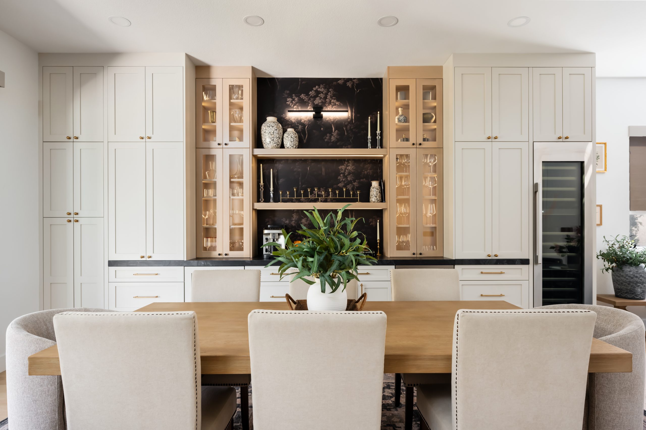 the-hearthstone-the-lakes-kitchen-remodel-kingdom-co Dry bar with dark botanical wallpaper, LED-lit glass cabinets, and wine column, Kingdom & Co. The Lakes remodel.