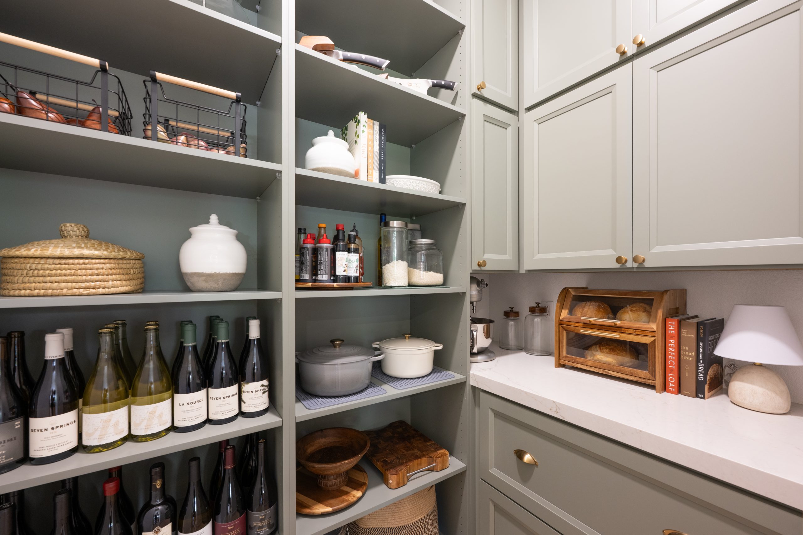 the-hearthstone-the-lakes-kitchen-remodel-kingdom-co Walk-in pantry with sage green shelves, wine storage, and dedicated sourdough bread station, Kingdom & Co. The Lakes.