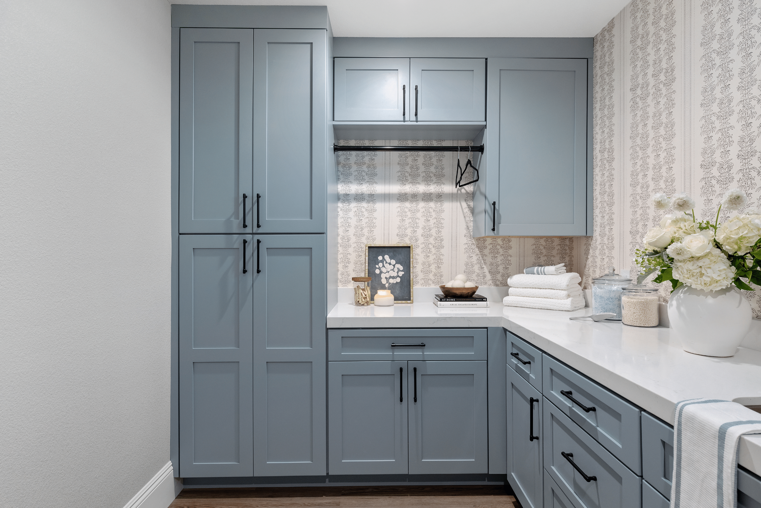 The Ashford (14) Laundry room after Willows Summerlin home renovation by Kingdom & Co. — powder blue cabinets, quartz counters, botanical block-print wallpaper, LG washer