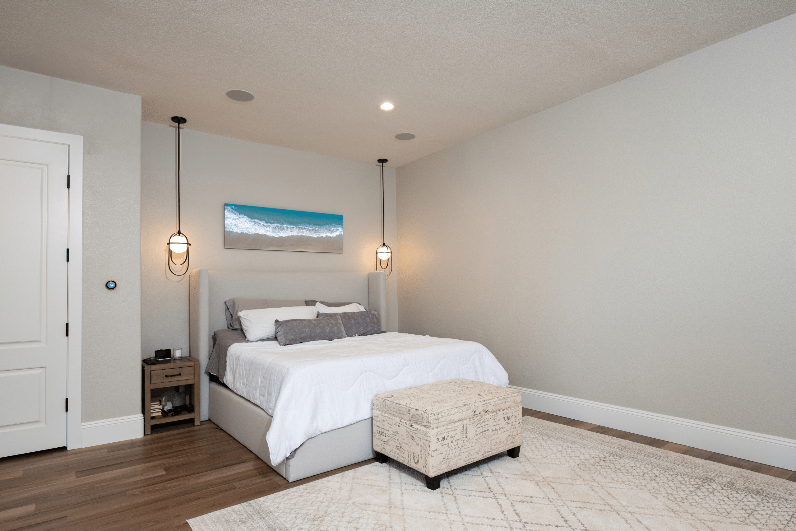 The Ashford (4) Primary bedroom after Willows Summerlin home renovation by Kingdom & Co. — greige walls, black iron pendant lights, wide-plank flooring
